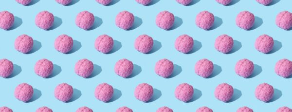 A pattern of pink brain-shaped candles arranged on a light blue background.