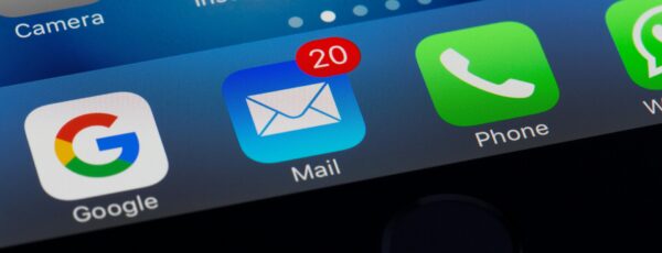 Close-up of a smartphone screen displaying app icons: Google, Mail with a notification badge showing 20, Phone, and WhatsApp.